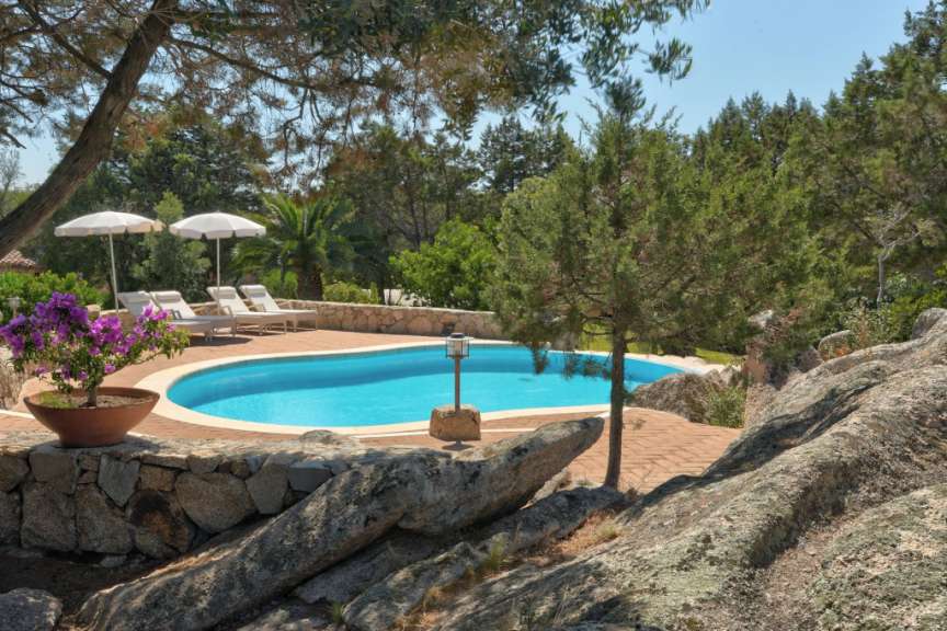 Ein großer Pool mit Liegestühlen und Sonnenschirmen umgeben