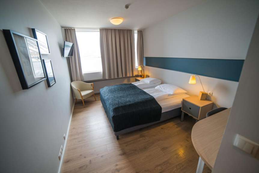 Ein Hotelzimmer mit einem Bett und einem Stuhl