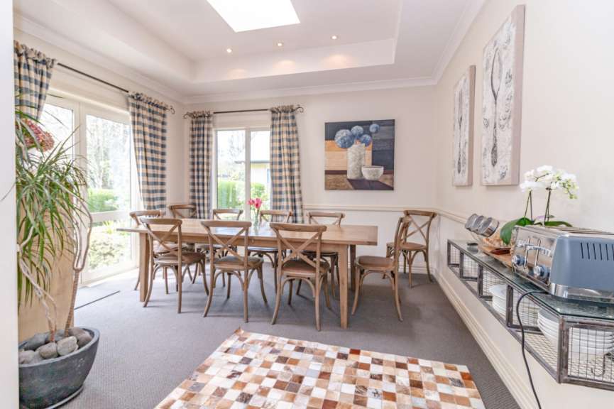 Ein Esszimmer mit einem Tisch und Stühlen und einem Gemälde an der Wand