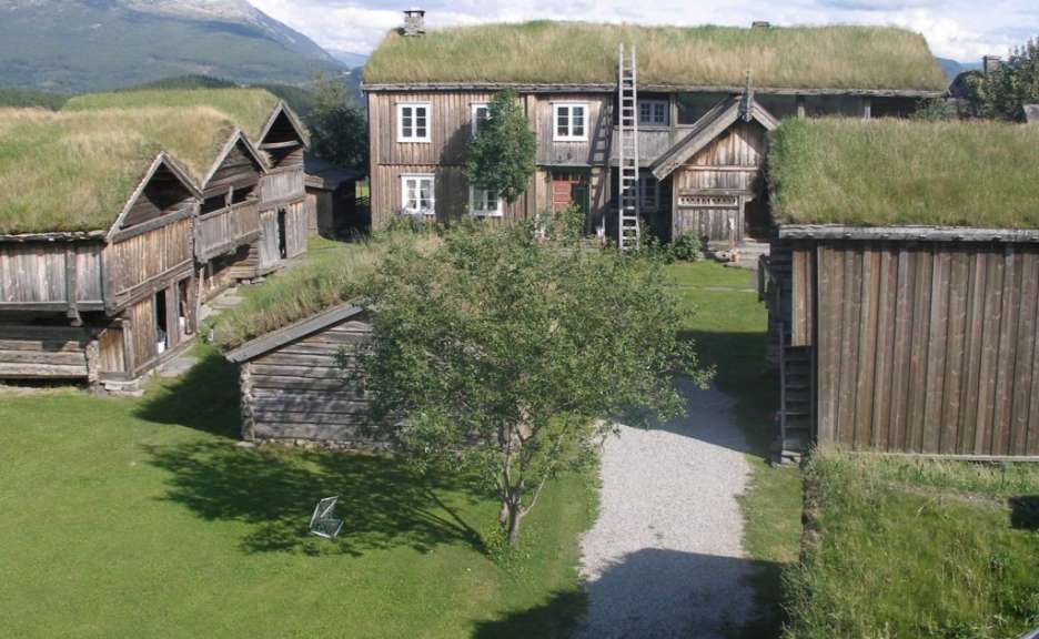 Eine Gruppe von Holzhäusern mit grasbedeckten Dächern