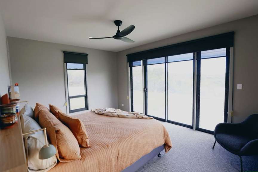Ein Schlafzimmer mit einem Bett und einem Deckenventilator