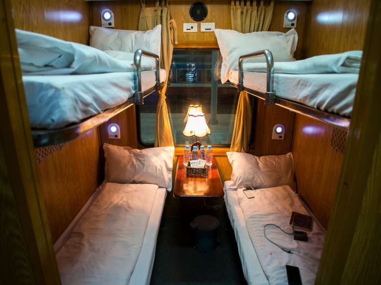 Ein Zimmer mit zwei Betten und einer Lampe