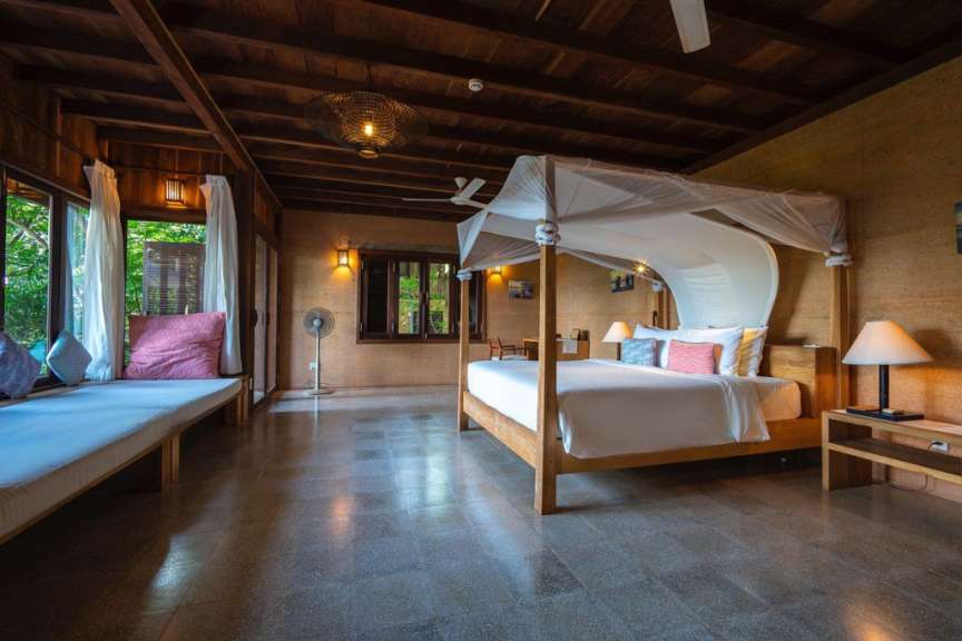 Ein Schlafzimmer mit einem Himmelbett und einem Ventilator