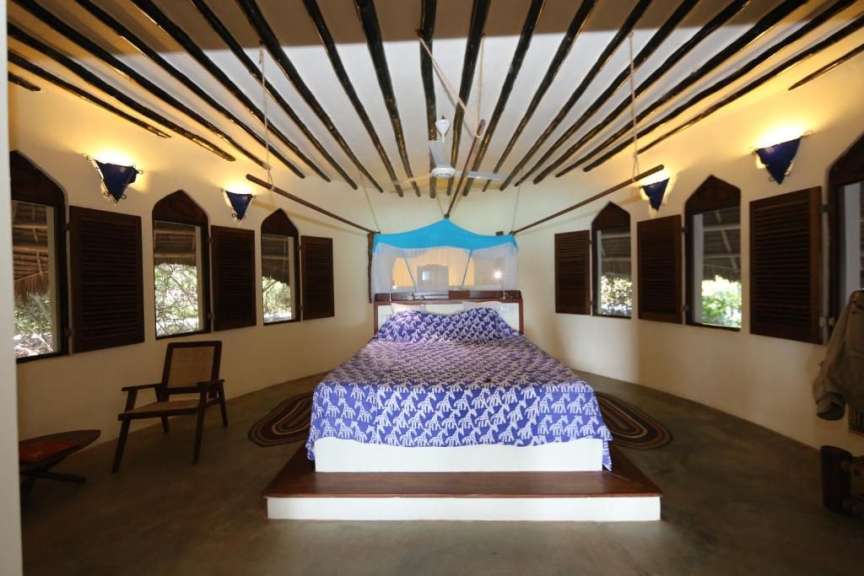 Ein Schlafzimmer mit einem Bett und vielen Fenstern
