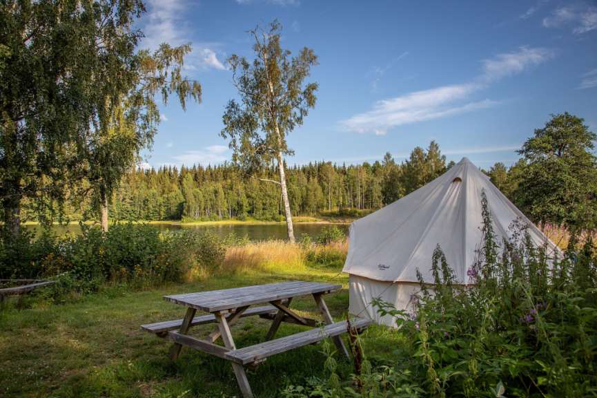 Ein weißes Zelt steht neben einem Picknicktisch
