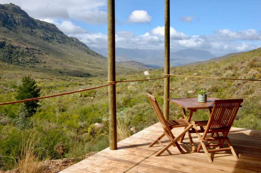 Ein Tisch und Stühle auf einem Deck mit Blick auf die Berge