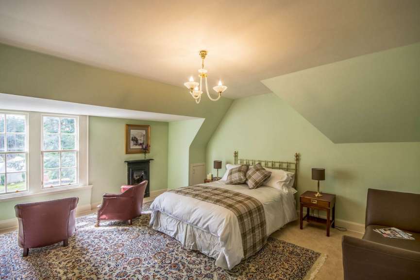 Ein Schlafzimmer mit einem Bett und zwei Stühlen