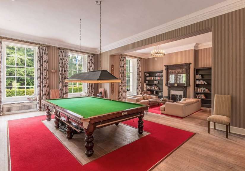 Ein Pooltisch in einem Wohnzimmer mit einem roten Teppich