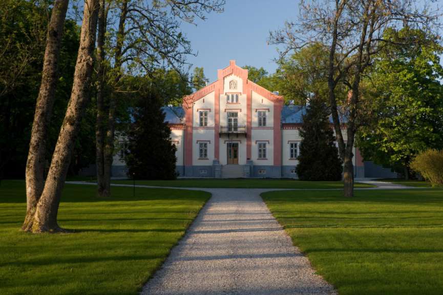 Ein rosa und weißes Gebäude mit einem weißen Weg davor