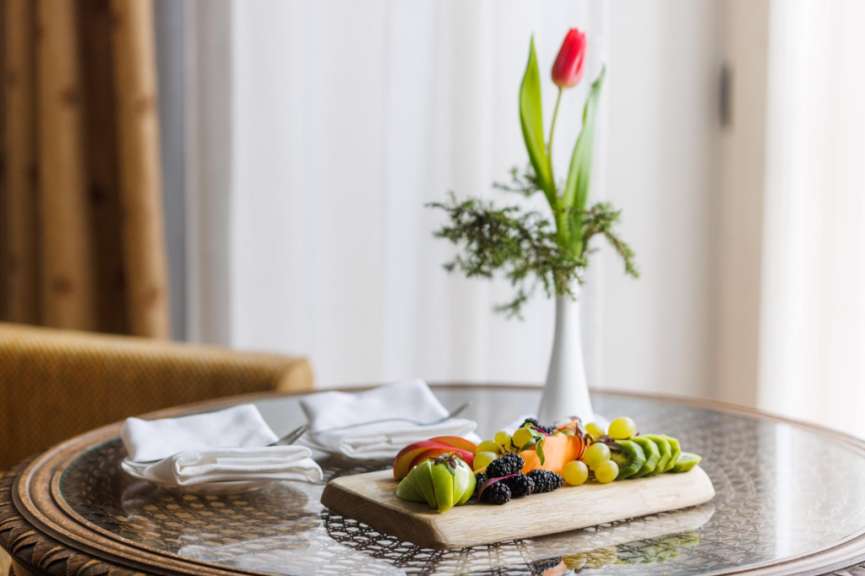 Auf einem glastisch steht ein holzbrett mit frischem obst