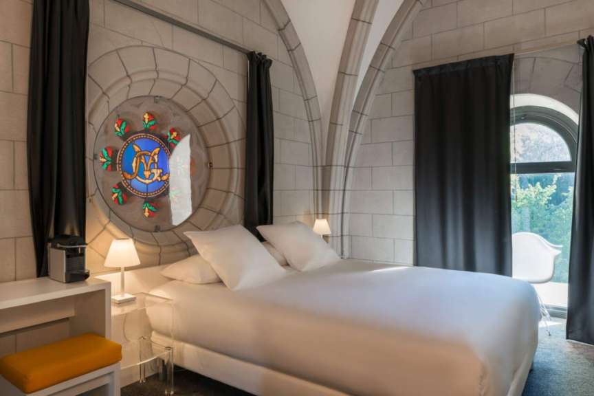 Ein Schlafzimmer mit einem Bett und einem Buntglasfenster