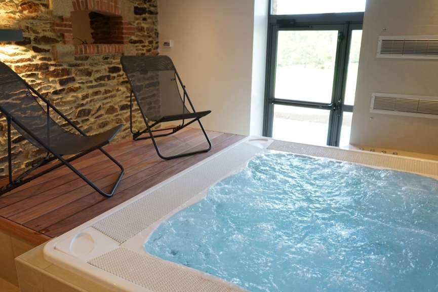 Ein Whirlpool mit blauem Wasser und zwei Stühlen davor