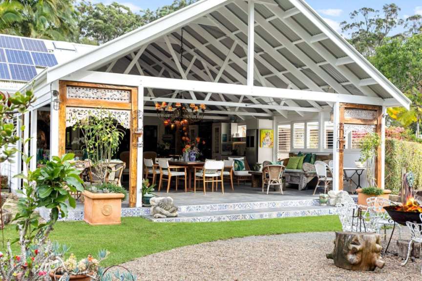 Eine weiße Veranda mit einem Tisch und Stühlen darauf