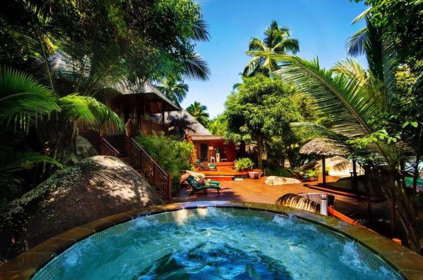 Ein Whirlpool in einem tropischen Garten neben einem Haus
