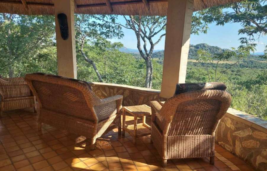Zwei Weidenstühle sitzen auf einer Veranda mit Blick auf den Dschungel
