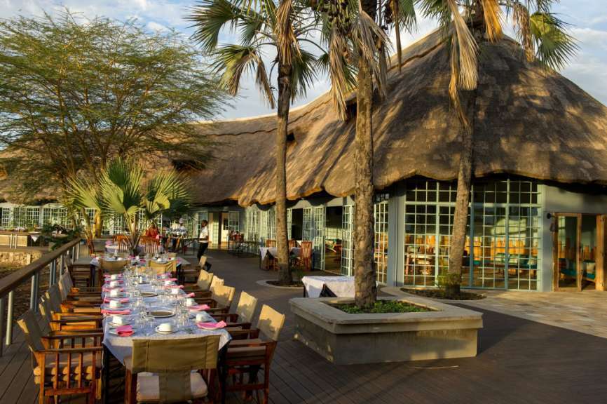 Ein Restaurant mit Strohdach und Tisch und Stühlen