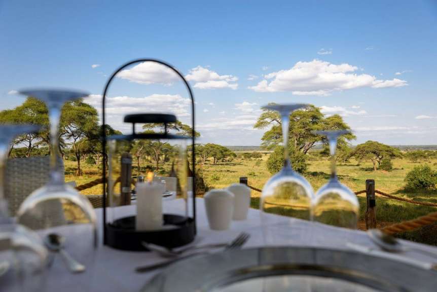 Ein Tisch mit Kerzen und Weingläsern mit einer Landschaft im Hintergrund