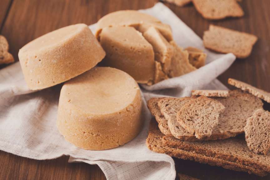 Ein Stück Brot neben einem Stück Käse auf einem Tisch
