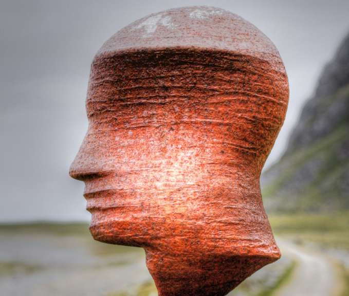 Eine rostige Statue eines Mannes mit einer Straße im Hintergrund