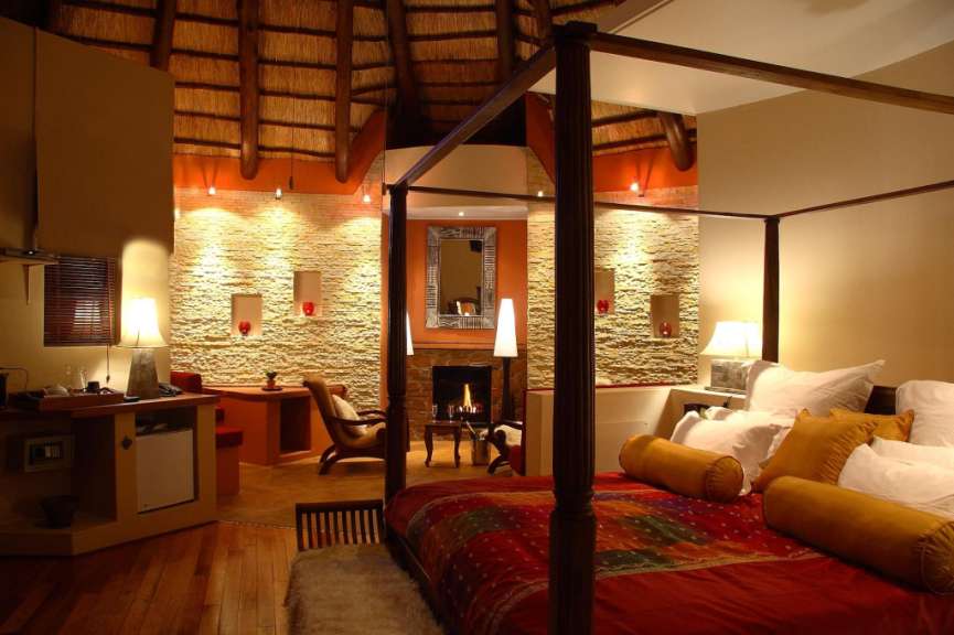 Ein Schlafzimmer mit einem Himmelbett und einem Kamin