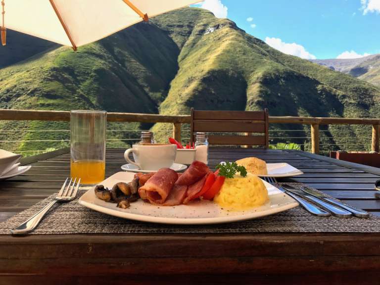 Ein tisch mit einem teller mit essen und einem berg im hintergrund