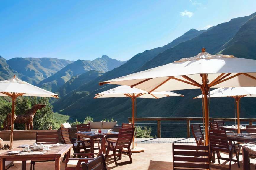 Tische und Stühle auf einer Terrasse mit Blick auf die Berge