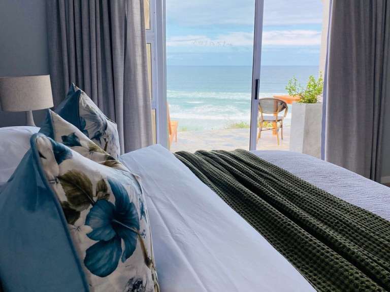Ein Bett mit blauen Blumenkissen und einer grünen Decke