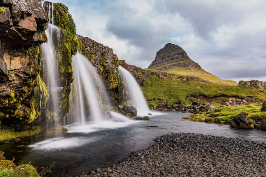 Ein Wasserfall mit einem Berg im Hintergrund