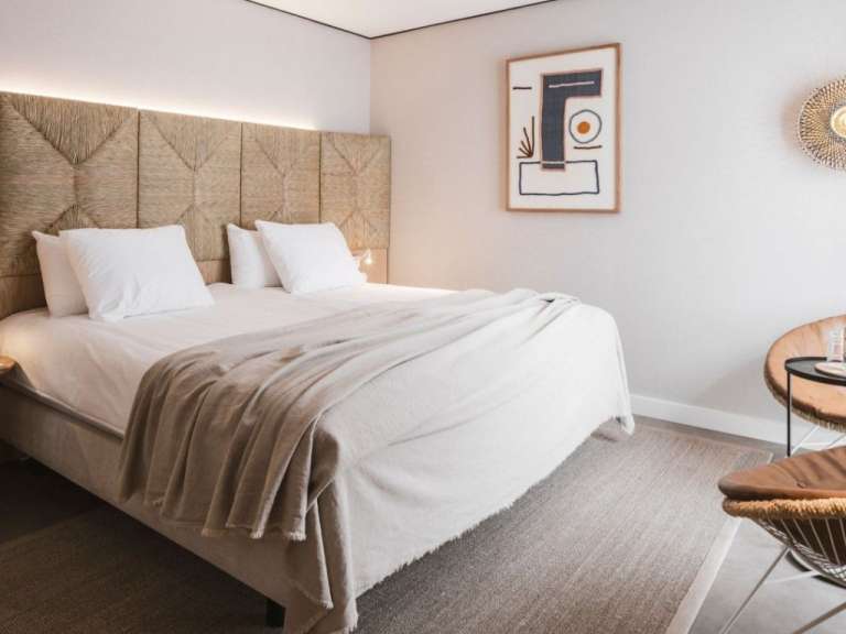 Ein Schlafzimmer mit einem Bett und einem Gemälde an der Wand