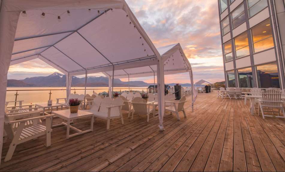 Eine Terrasse mit weißen Möbeln und weißen Zelten