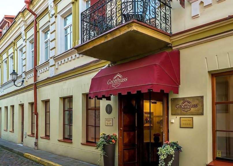 Ein Gebäude mit einem roten Vorhang und einem Schild, das sagt grotthuss hotel