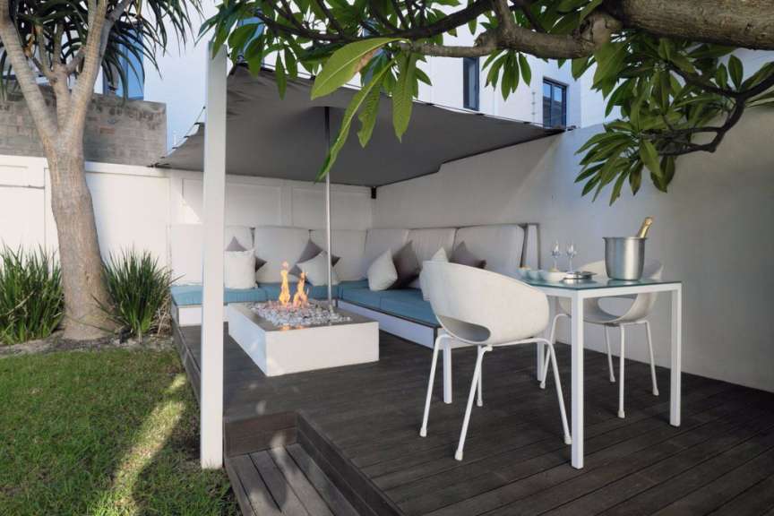 Eine Terrasse mit einem Tisch und Stühlen und einem Kamin