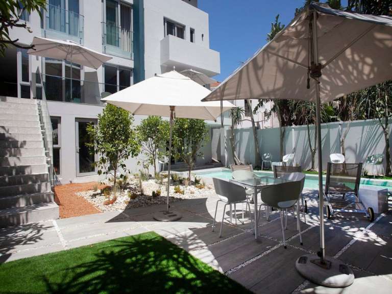 Eine Terrasse mit Tisch und Stühlen und Sonnenschirmen