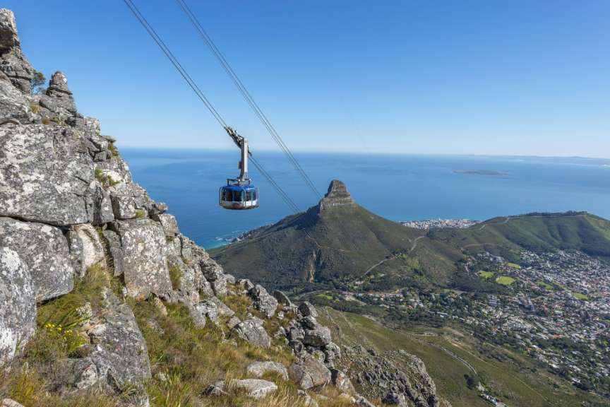 Eine Seilbahn fährt auf einem Berg mit Blick auf das Meer