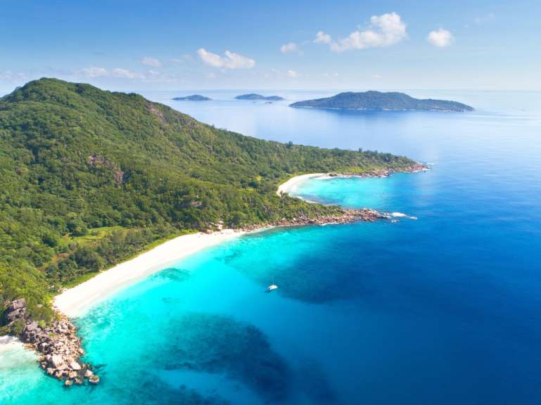 Ein Strand mit einem weißen Sandstrand und einem blauen Ozean