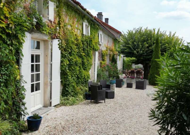 Ein Haus mit einem Tisch und Stühlen davor