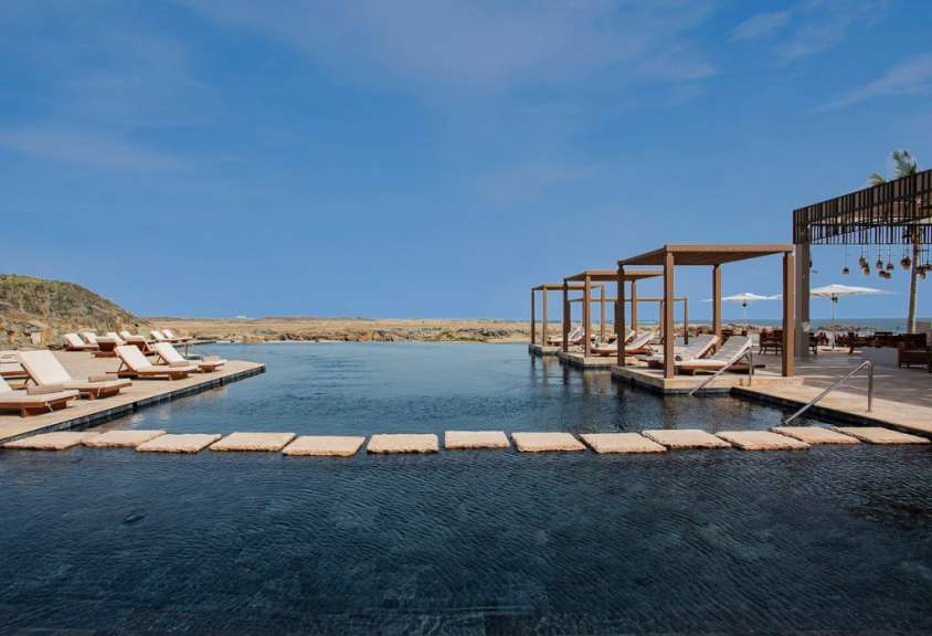 Ein großer Pool mit Liegestühlen und Sonnenschirmen umgeben
