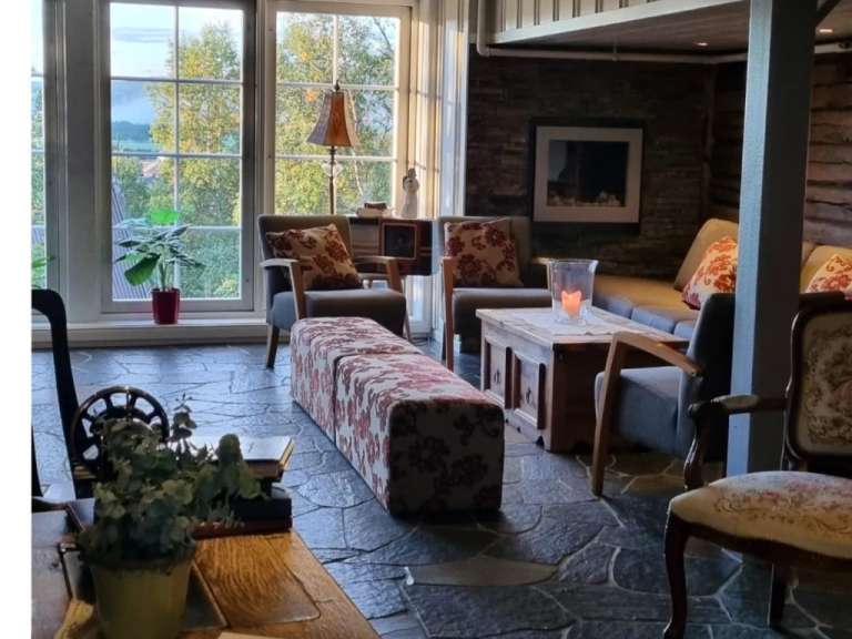 Ein Wohnzimmer mit vielen Möbeln und einem großen Fenster