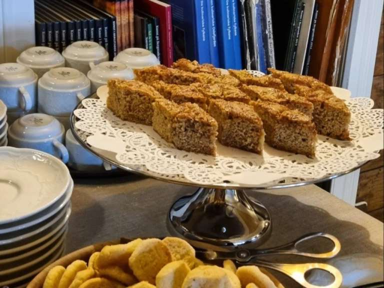 Ein Tablett mit Kuchen und Kekse auf einem Tisch mit Büchern im Hintergrund