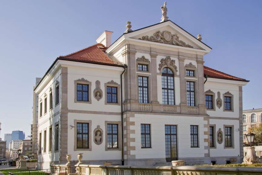 Ein weißes Gebäude mit einem roten Dach und vielen Fenstern