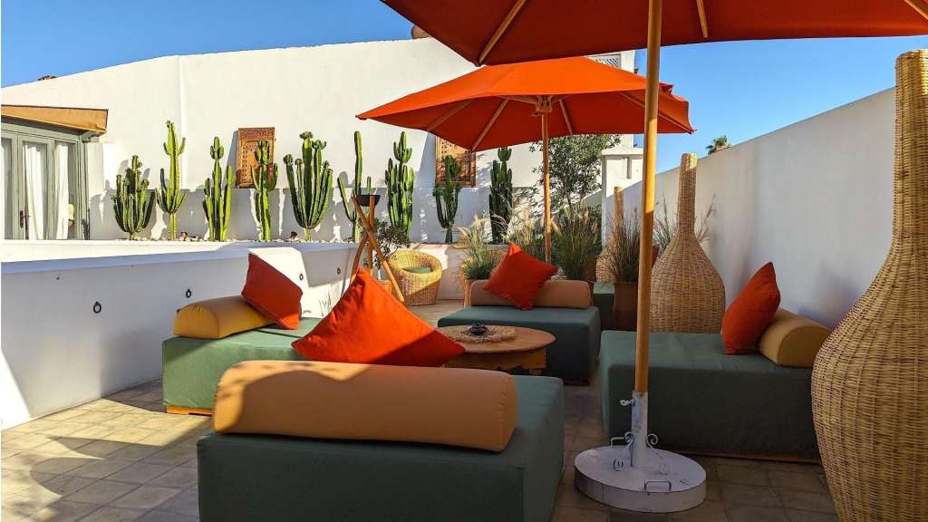 Eine Terrasse mit Möbeln und einem orangefarbenen Regenschirm