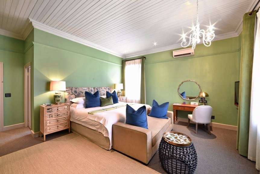 Ein Schlafzimmer mit grünen Wänden und einem großen Bett