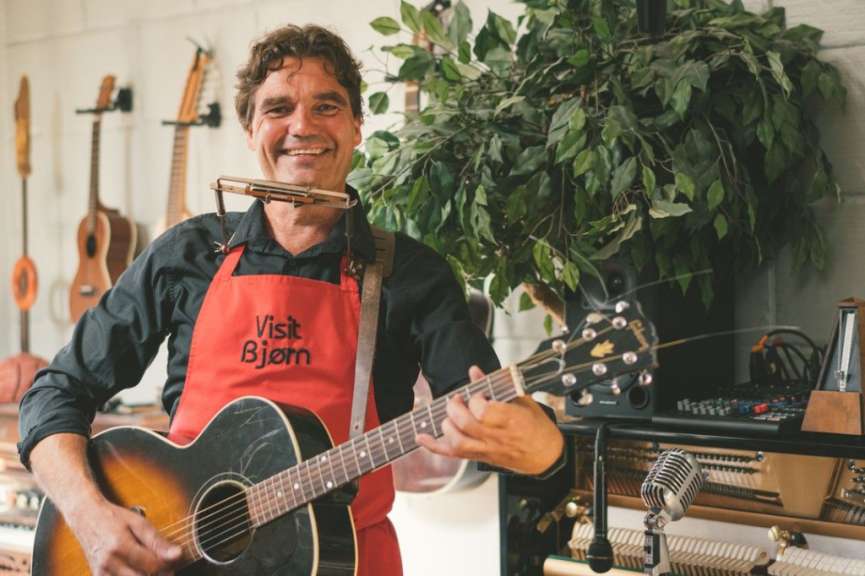 Ein Mann in einer roten Schürze spielt eine Gitarre