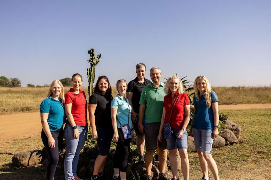 Eine Gruppe von Menschen steht nebeneinander und posiert für ein Foto