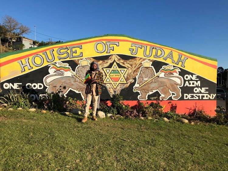 Ein Mann steht vor einem Schild mit der Aufschrift „ Hause judah “