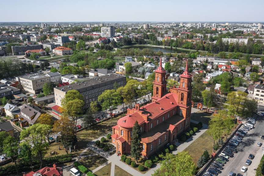 Eine Luftaufnahme einer Stadt mit einer roten Kirche im Vordergrund
