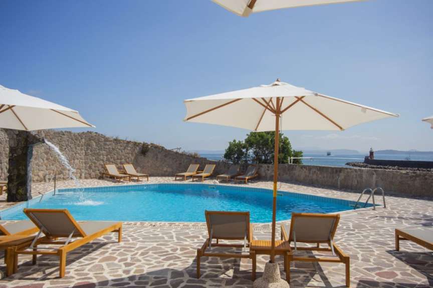 Ein Pool mit Liegestühlen und Sonnenschirmen um ihn