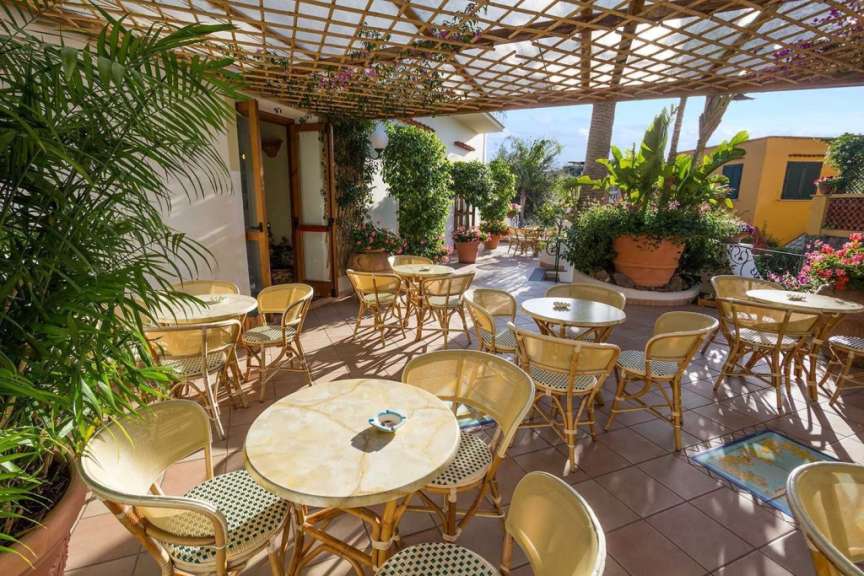 Eine Terrasse mit Tischen und Stühlen und einer Pergola