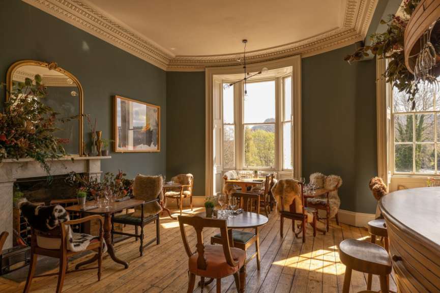 Ein Wohnzimmer mit vielen Stühlen und Tischen