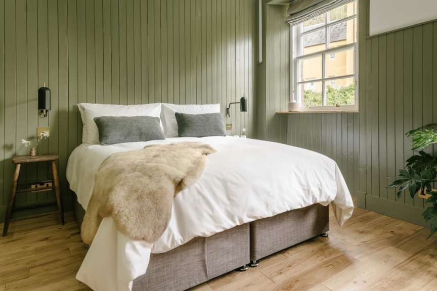 Ein Schlafzimmer mit grünen Wänden und einem Bett